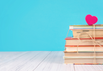 Stack of books with heart on top blue background
