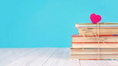 Stack of books with heart on top blue background